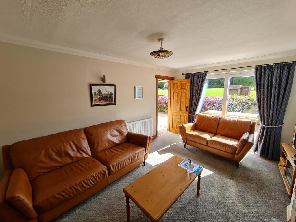 sala de estar con sofá y mesa de centro en Coach House en Penrith