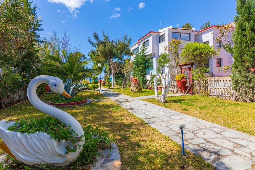 a statue of a swan in the yard of a house at Galazia Akti Seaside Apartments in Nikiti
