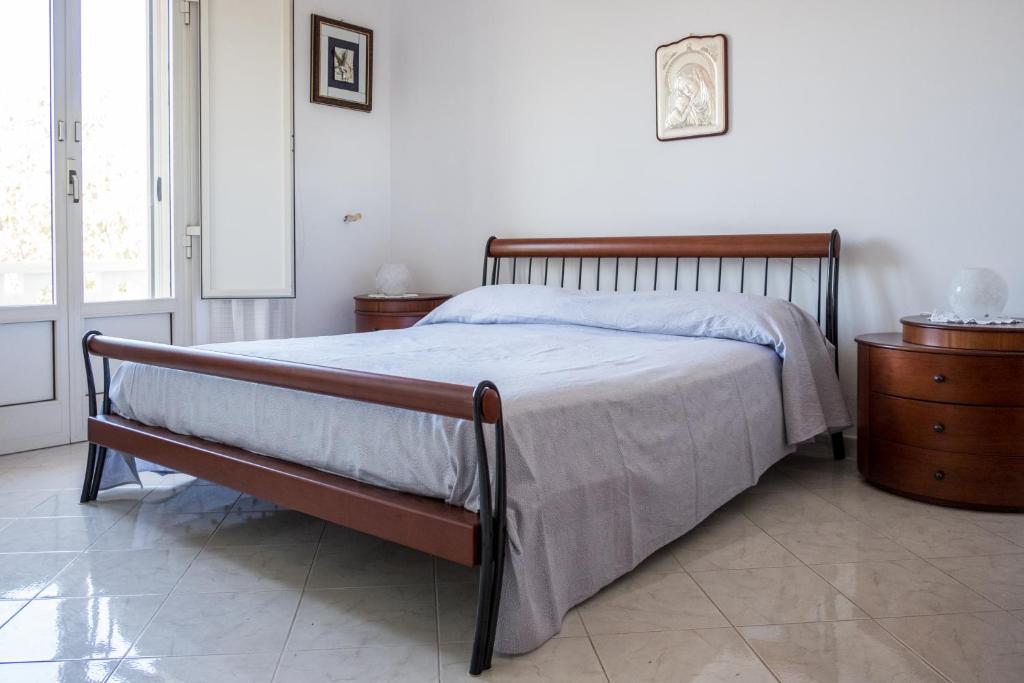 1 dormitorio con 1 cama con marco de madera en Regina di Puglia Casa Vacanze, en Monopoli