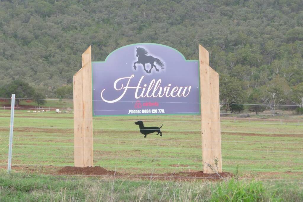 un gran cartel con un perro negro en un campo en Hillview, a quiet country escape with views., en Yangan