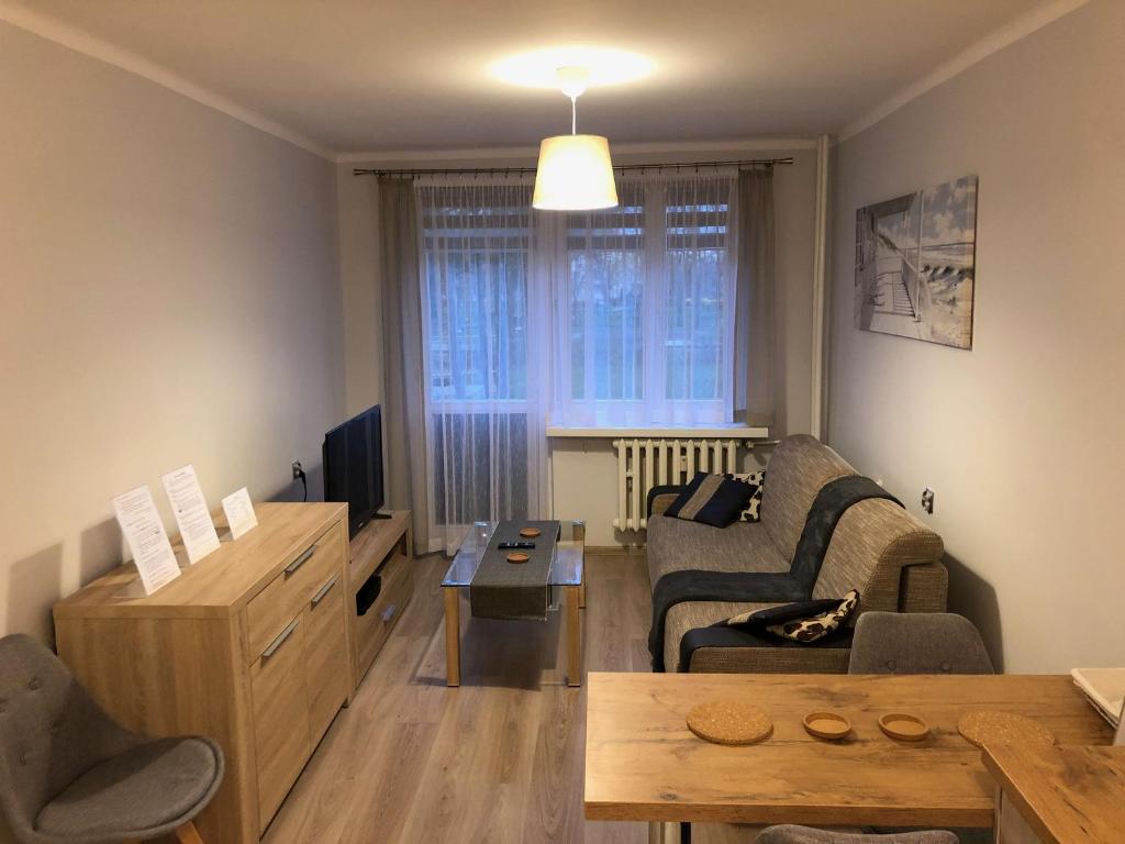ein Wohnzimmer mit einem Sofa und einem Tisch in der Unterkunft Apartament na Wierzbowej parter in Kędzierzyn-Koźle