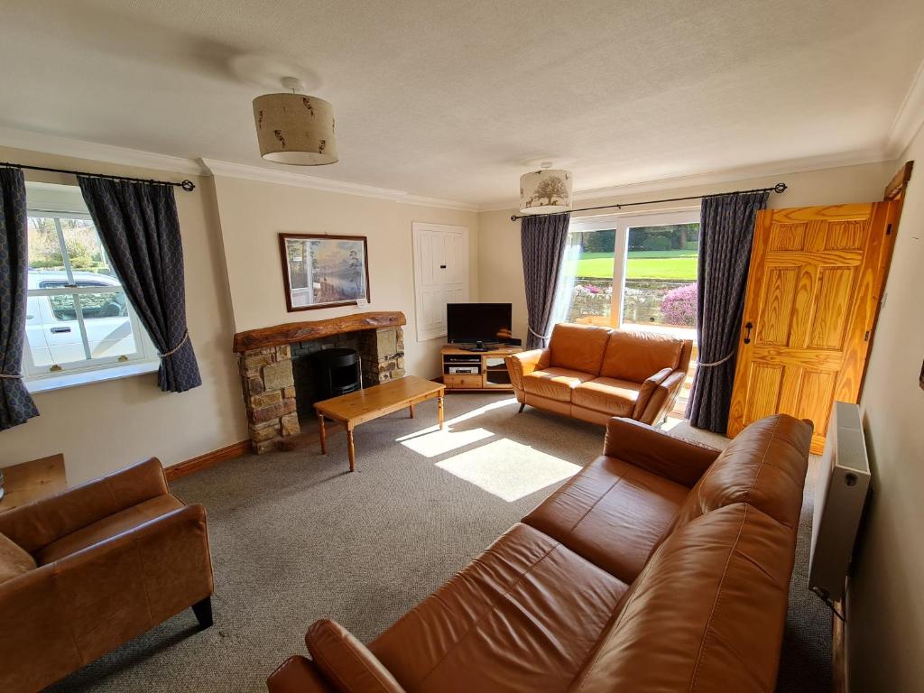 a living room with a couch and a fireplace at Stable Cottage in Penrith
