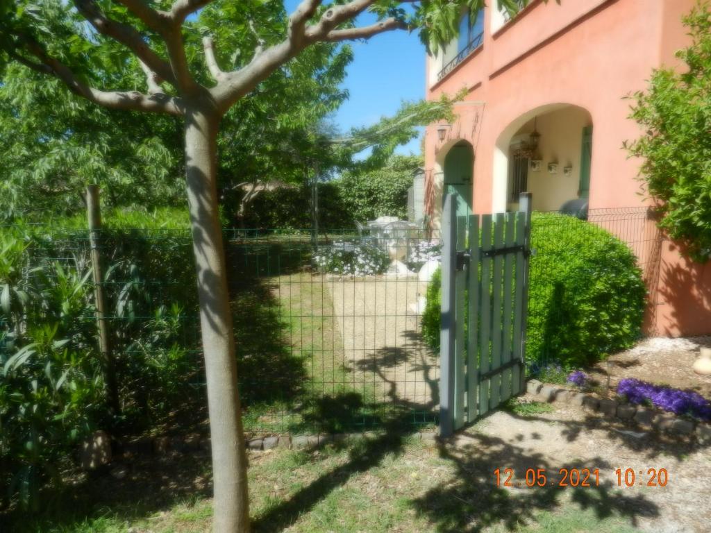 a green gate in front of a pink house at L&#39;Oliveraie in Draguignan