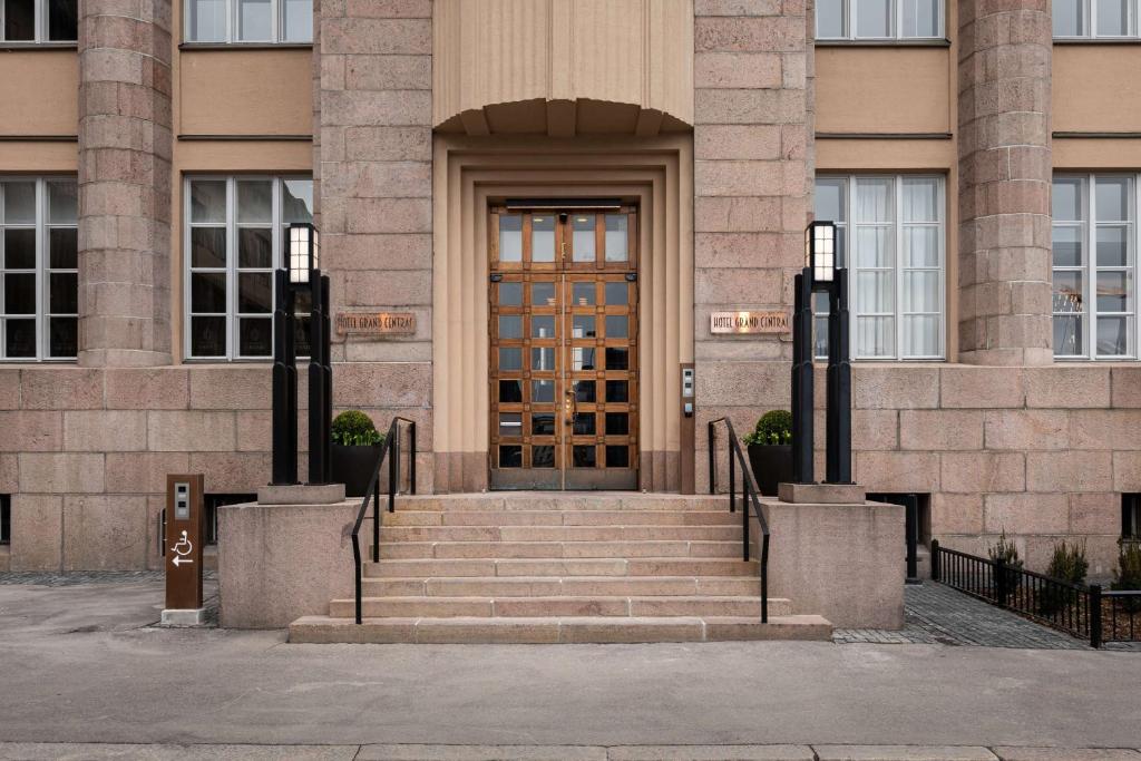 uma porta da frente de um edifício com escadas à frente em Scandic Grand Central Helsinki em Helsinque