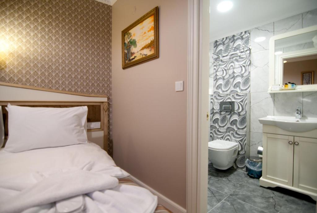 een kleine slaapkamer met een bed en een wastafel bij Mevlana Hotel in Istanbul