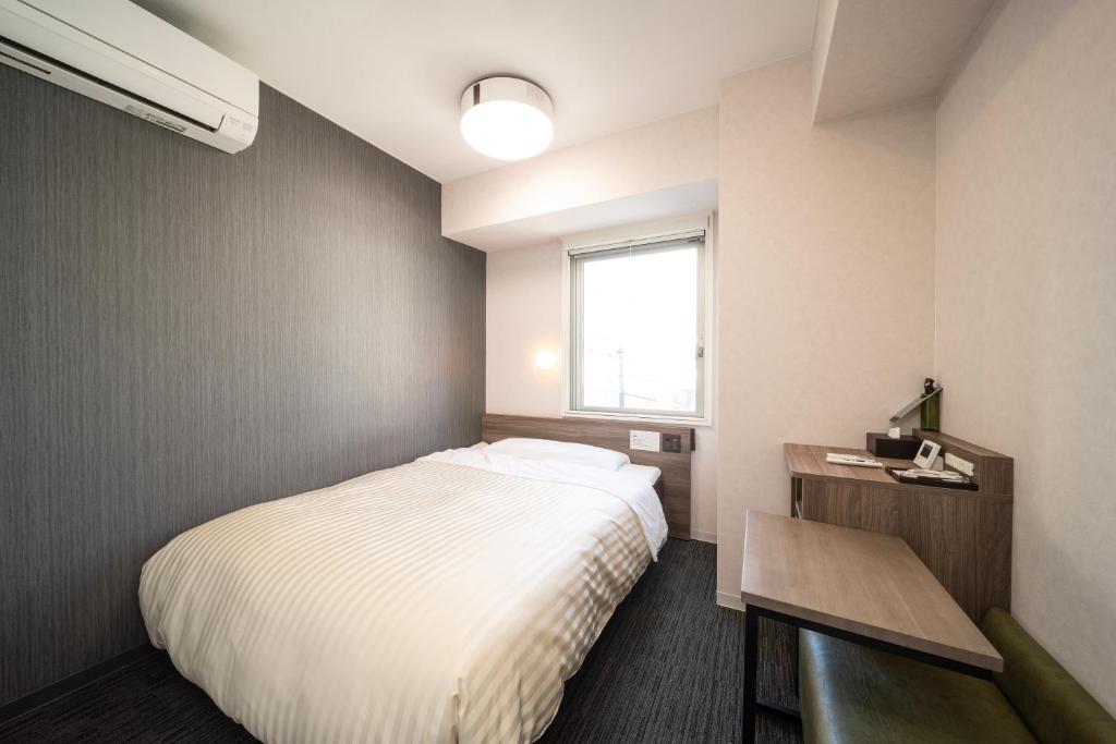Postel nebo postele na pokoji v ubytování Super Hotel Hiroshima Yagenboridori