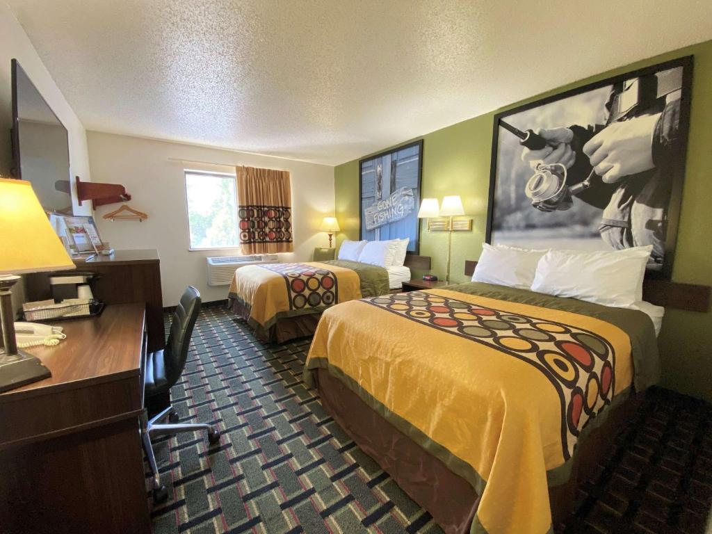 Una habitación de hotel con dos camas y un escritorio. en Super 8 by Wyndham Newport News&#47;Jefferson Ave., en Newport News