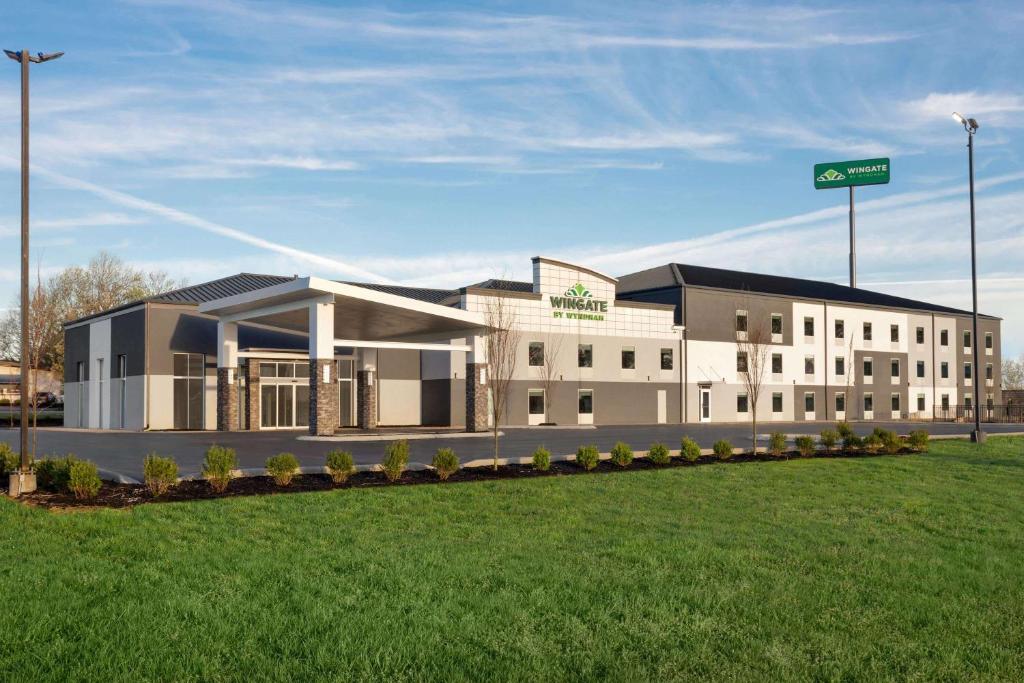 un grand bâtiment avec un panneau vert au-dessus dans l'établissement Wingate by Wyndham Murfreesboro-NEAR MTSU, à Murfreesboro