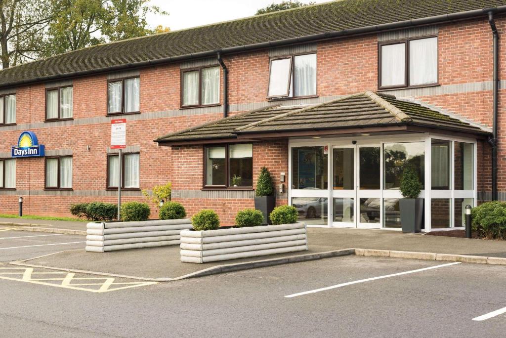 un bâtiment en briques rouges avec un parking dans l'établissement Days Inn Corley NEC - M6, à Coventry