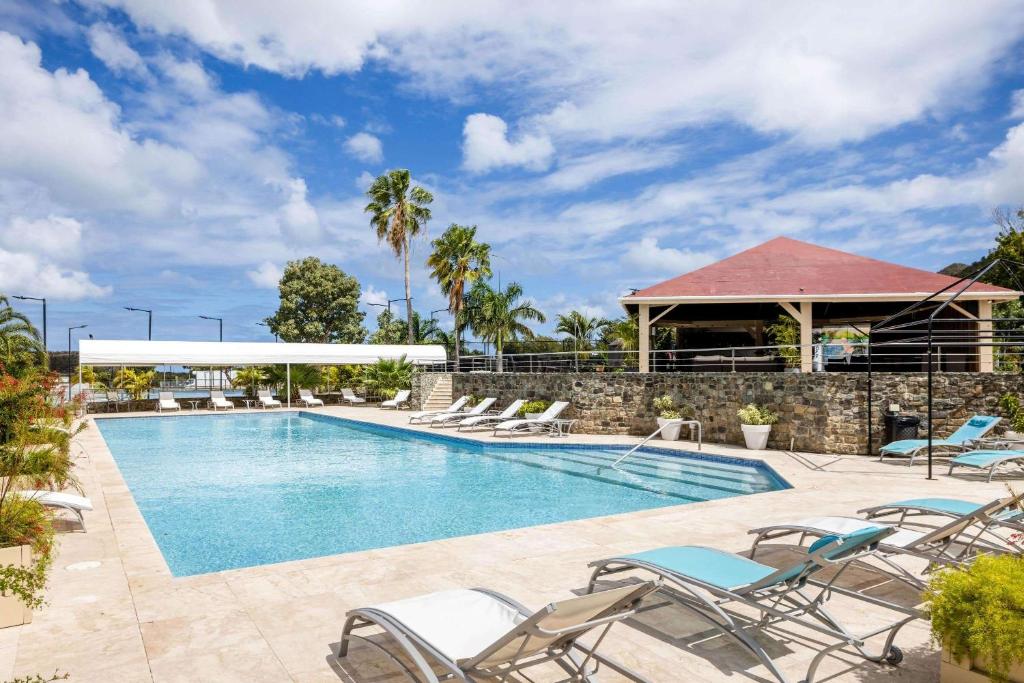 a swimming pool with chairs and a building at Port de Plaisance Resort, Trademark Collection by Wyndham in Philipsburg