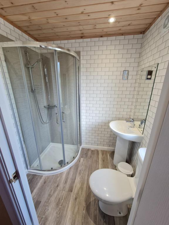 a bathroom with a shower and a toilet and a sink at Park Lodge in Penrith