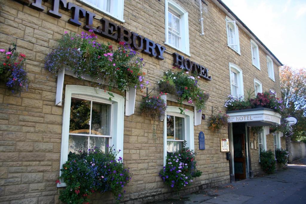 un edificio de ladrillo con flores a un lado. en Littlebury Hotel, en Bicester