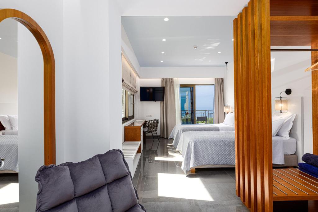 um quarto de hotel com uma cama e um sofá em CHRISTOS Élite Sea View Suite Adults Only em Plakiás