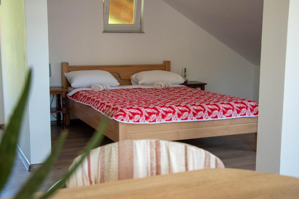 a bedroom with a bed with a red blanket at Big Mama's Apartments in Konjic