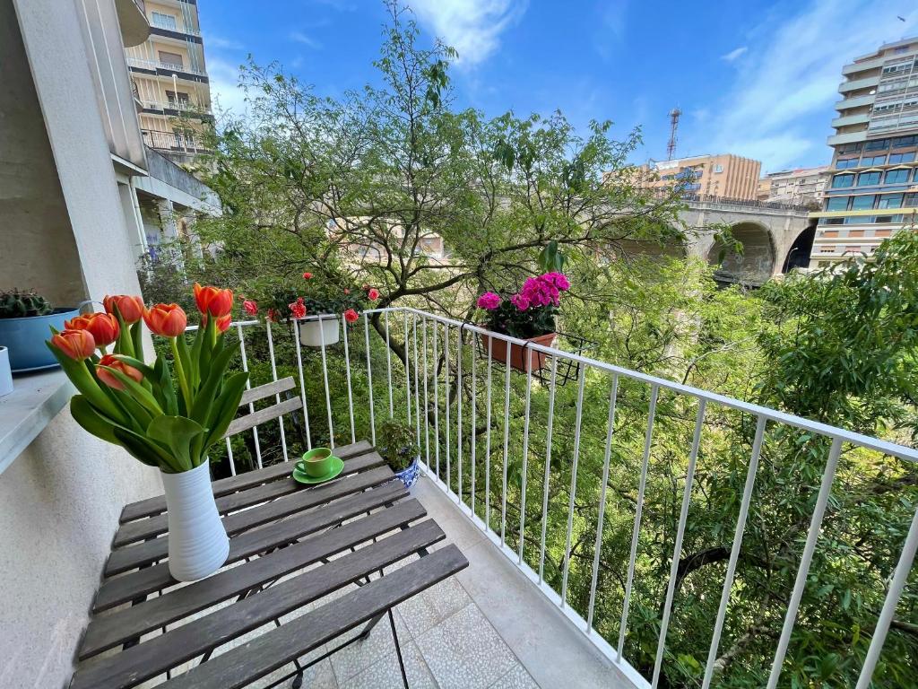 a balcony with a bench with flowers in a vase at Finestra sui Ponti in Ragusa