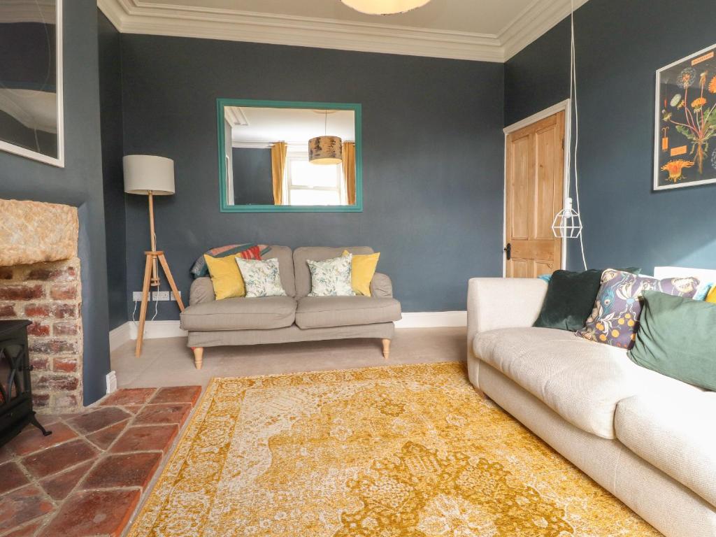 a living room with a couch and a fireplace at Castlewood Cottage in Skipton