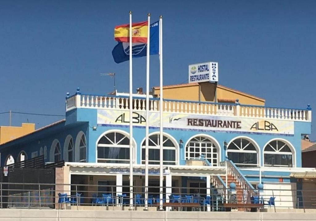 a building with a flag on top of it at Hostal Alba in La Mata