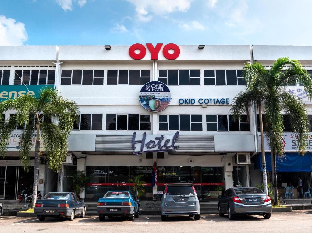 un gran edificio con coches estacionados frente a él en Okid Hotel, en Johor Bahru