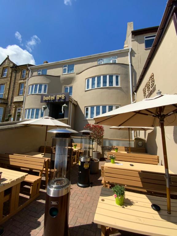 un patio con mesas y sombrillas y un edificio en Hotel No 8, en Skegness