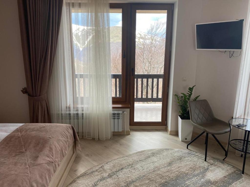 a bedroom with a bed and a view of a balcony at Vershyna in Pilipets