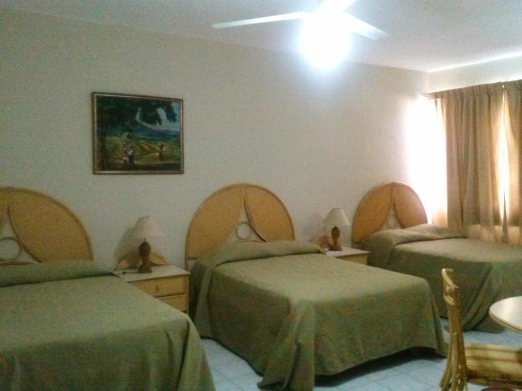 a hospital room with two beds and a table at Apartahotel Jardines Metropolitanos in Santiago de los Caballeros