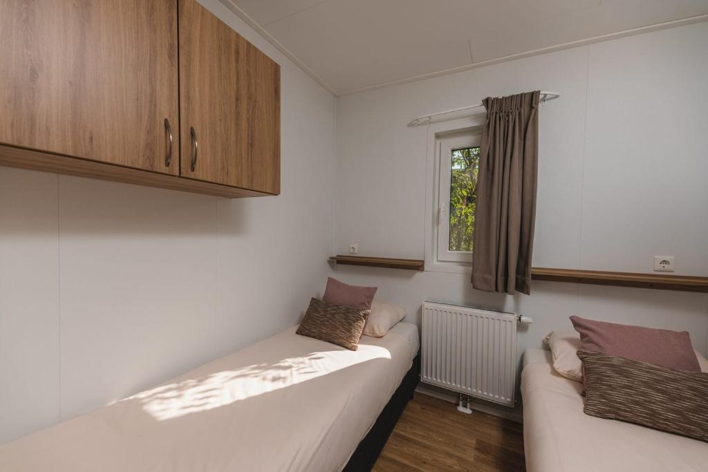 a living room with a couch and a window at Panorama Lodge met hottub 4p in Rijssen