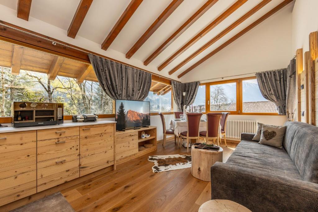 ein Wohnzimmer mit einem Sofa und einem TV in der Unterkunft Chalet Mountain Plaza - Apt Overland in Pinzolo