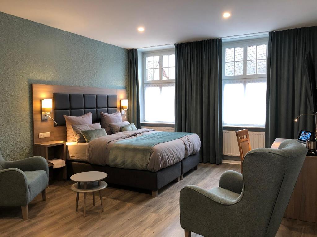 une chambre d'hôtel avec un lit et deux chaises dans l'établissement AKZENT Hotel Restaurant Roter Ochse Rhens bei Koblenz, à Rhens