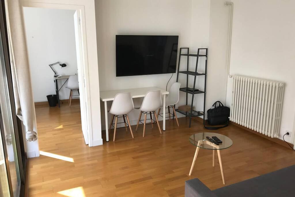 d'un salon avec une table, des chaises et une télévision à écran plat. dans l'établissement Logement 6P BALCON/ MODERNE HYPER CENTRE, à Caen