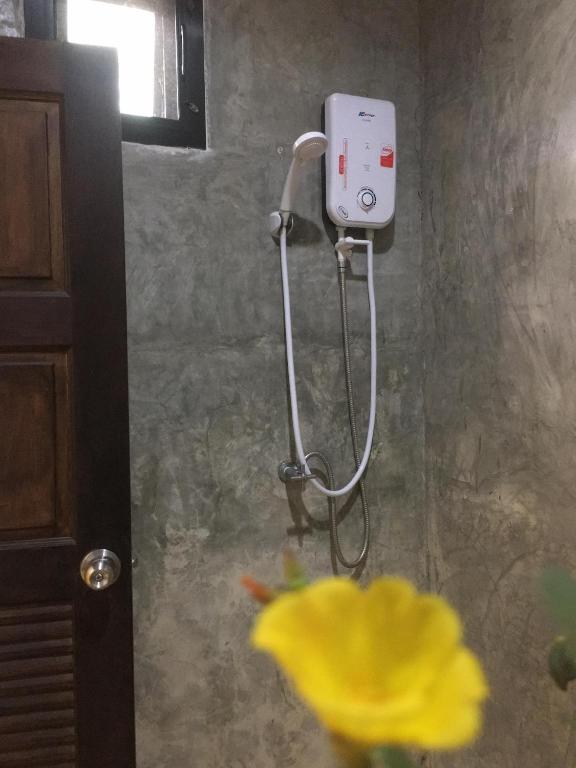 a shower in a bathroom with a yellow flower at Rawai Whale Resort in Rawai Beach