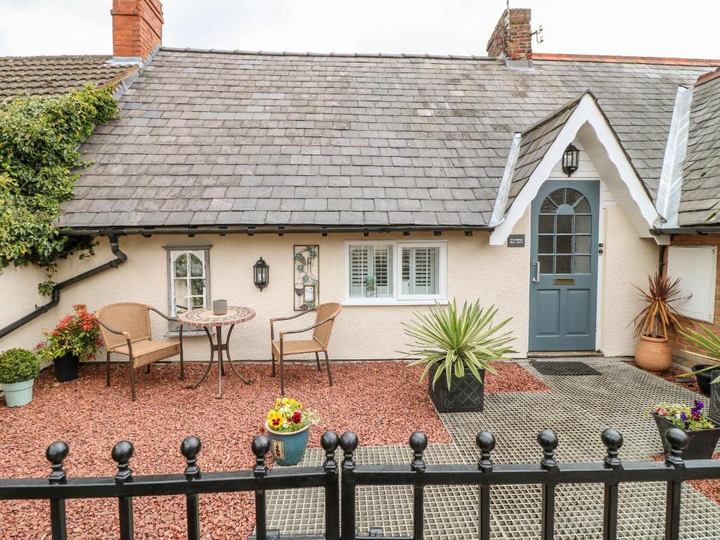 a small house with a blue door and a patio at The Hideout in Oakham