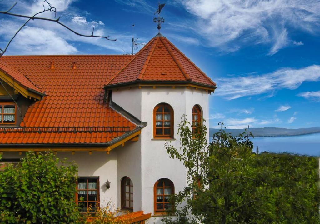 ein weißes Haus mit orangefarbenem Dach in der Unterkunft Ferienhaus Bodensee Seeblick in Gaienhofen
