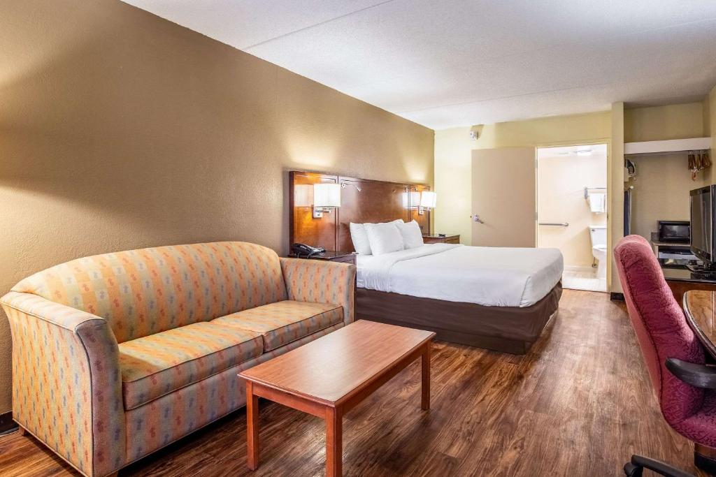 ノーフォークにあるEcono Lodge Naval Station Norfolkのベッドとソファのあるホテルの部屋