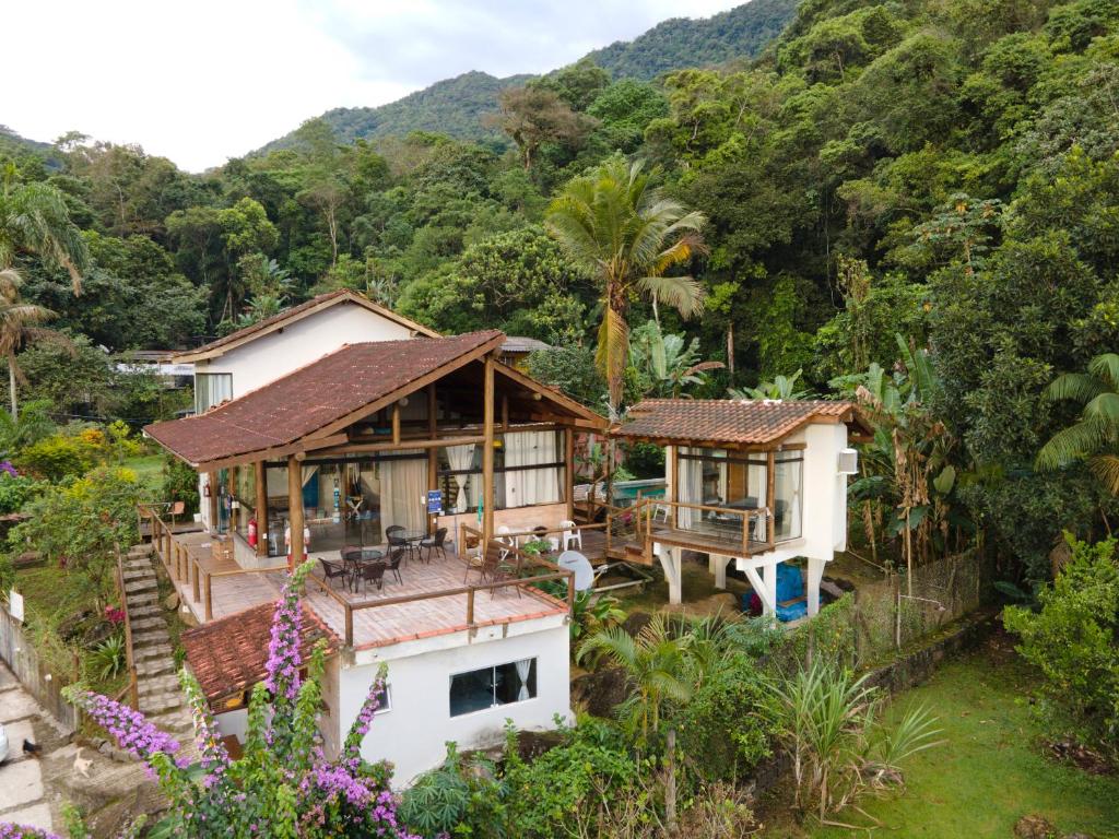 uma vista aérea de uma casa com montanhas ao fundo em Haleiwa chalés e suítes - A Guest House do Prumirim em Ubatuba