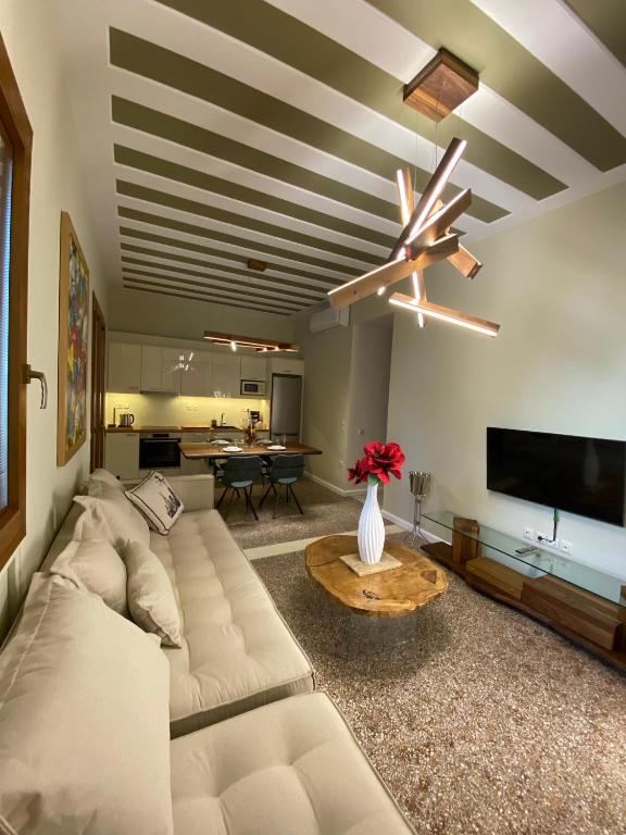 a living room with a white couch and a ceiling fan at Andros 4 All Seasons Villas & Suites in Andros