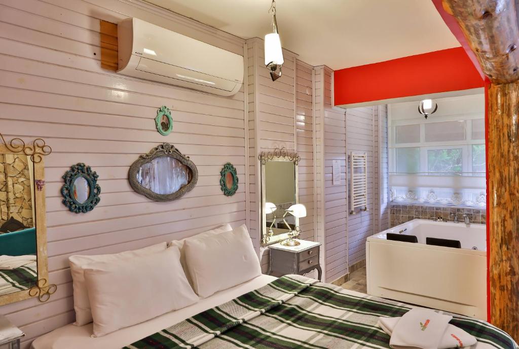 a bedroom with a bed and a tub and a sink at Park Mandalin Hotel - Adult only in Ağva