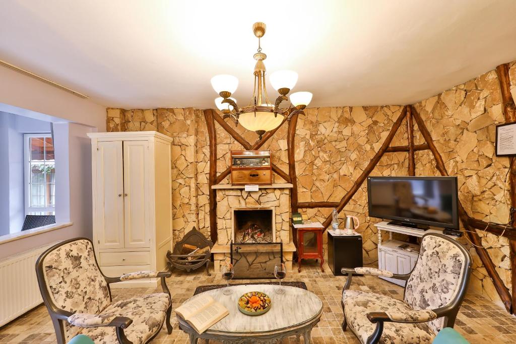 a living room with a stone wall with a fireplace at Park Mandalin Hotel - Adult only in Ağva