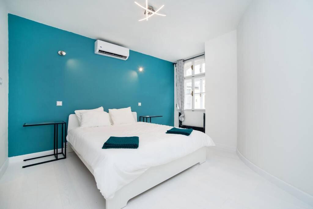 a bedroom with a white bed and blue walls at Old Town 1 Bedroom Oasis with AC and Double Shower in Prague