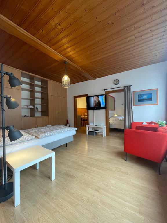 a living room with a bed and a red couch at City-apart Kitzbühel in Kitzbühel