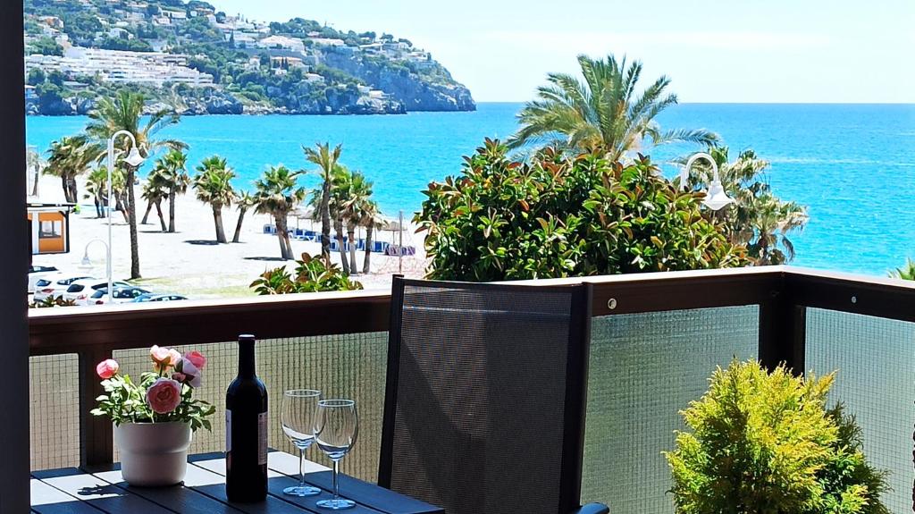 d'un balcon avec une table, des verres à vin et l'océan. dans l'établissement Bahia Deluxe, à La Herradura