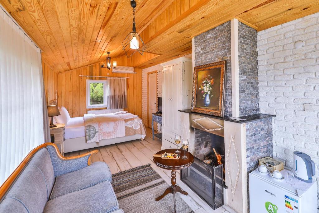 a living room with a fireplace and a bedroom at Park Mandalin Hotel - Adult only in Ağva