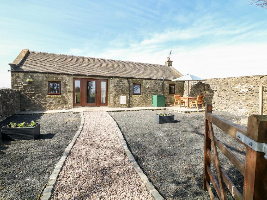 a stone cottage with a fence in front of it at Shepherds Retreat in Ashbourne