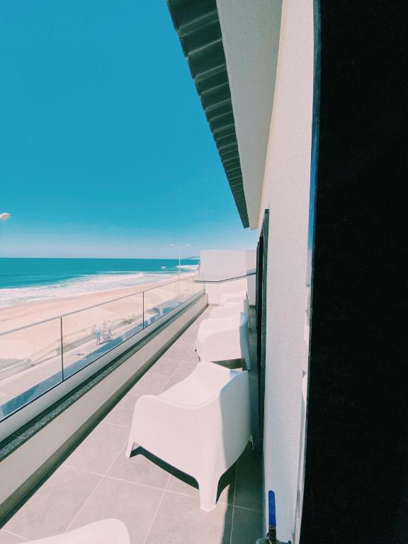 Blick auf den Strand vom Balkon eines Gebäudes in der Unterkunft Maré Viva Bed & Breakfast in Rego da Leirosa