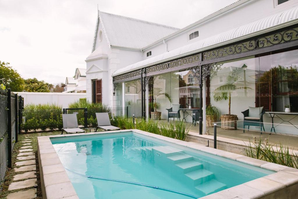 a swimming pool in front of a house at Heritage House in Stellenbosch