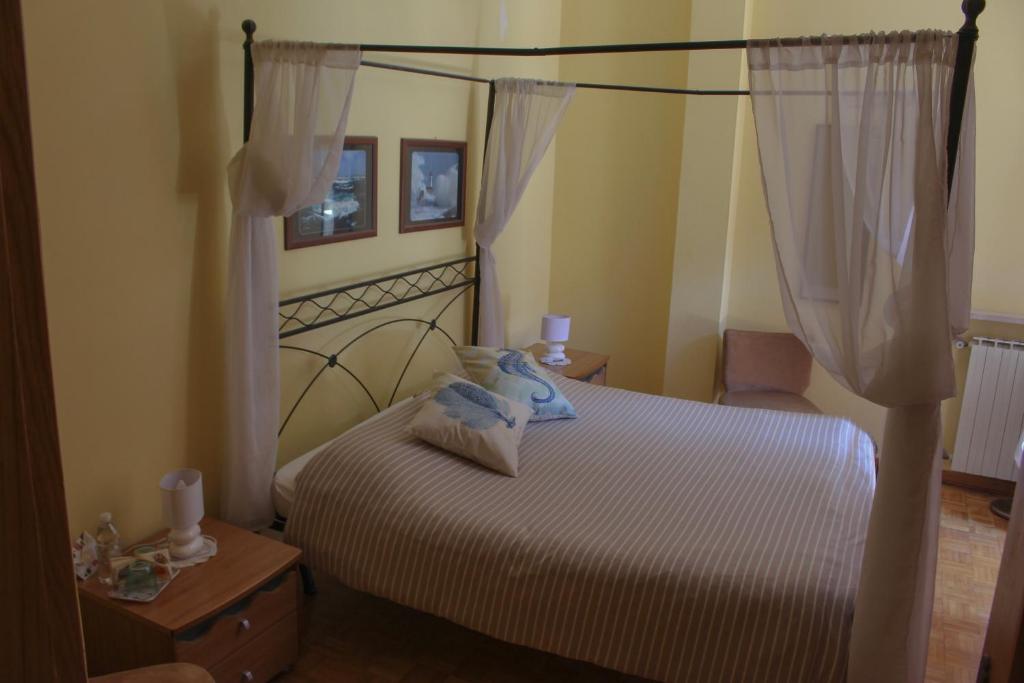 a bedroom with a large bed with a canopy at Affittacamere Il Veliero in Duino