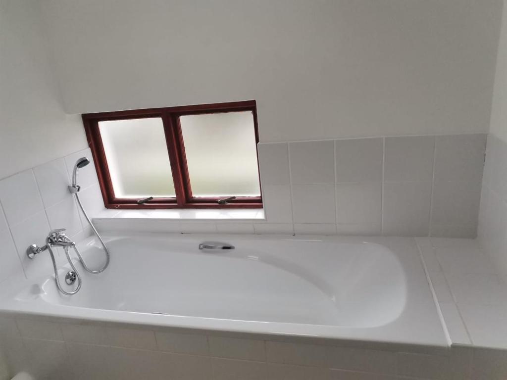 a bathroom with a bath tub with a window at 57 @ The Dunes in Plettenberg Bay