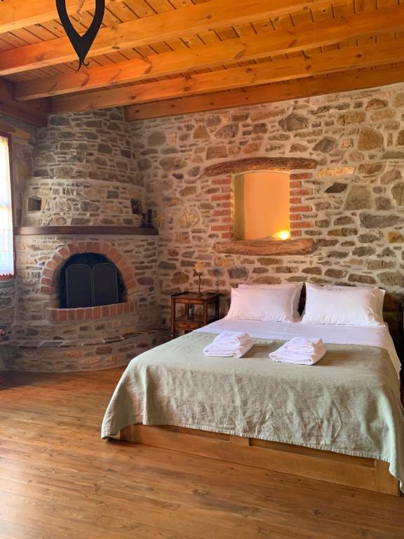 a bedroom with a bed and a stone wall at Lithos Homes in Volissos