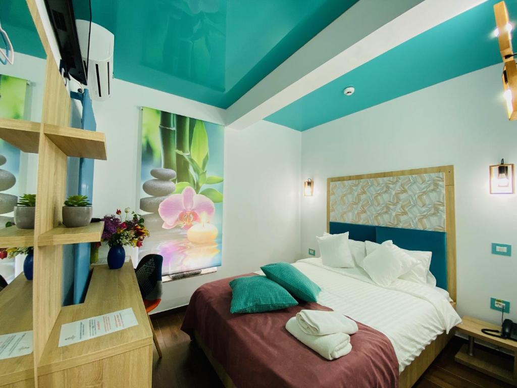 um quarto com uma cama grande e um tecto azul em MAREA NEAGRA Executive Rooms em Mamaia