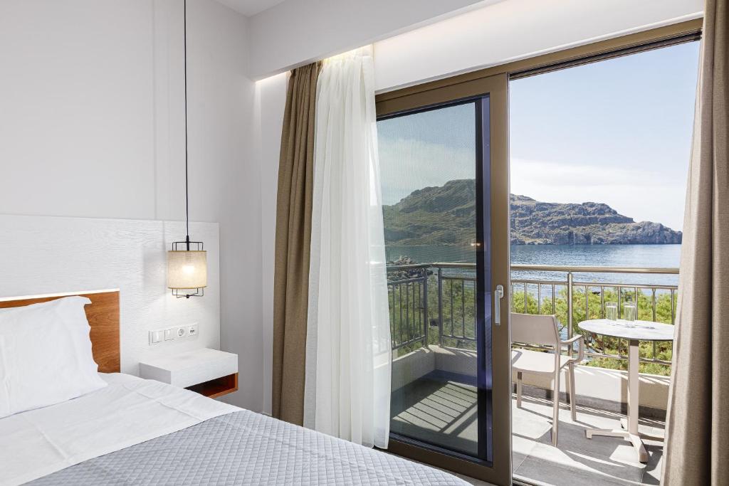 a bedroom with a bed and a balcony with a view at Elsa Exclusive Double Sea View - Adults Only in Plakias