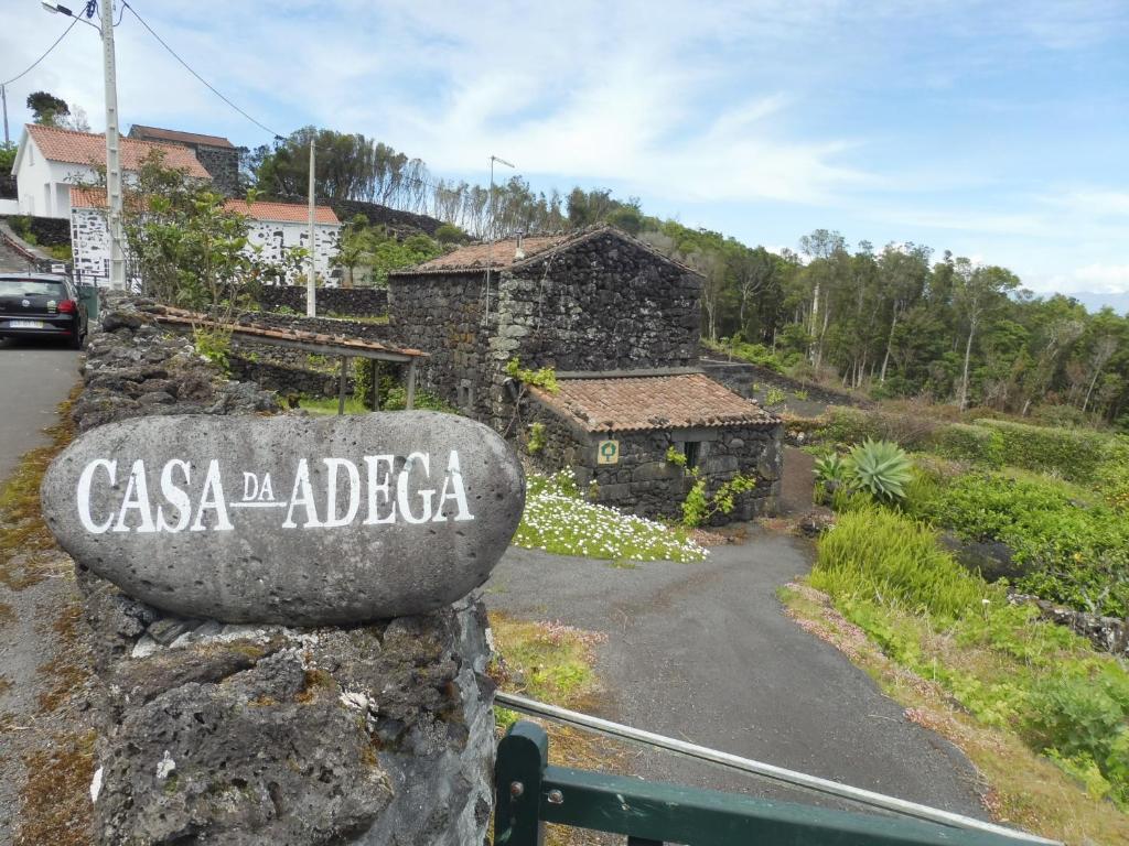 Prainha de BaixoにあるCasa da Adegaの石壁のカサ・アデリカを読む看板